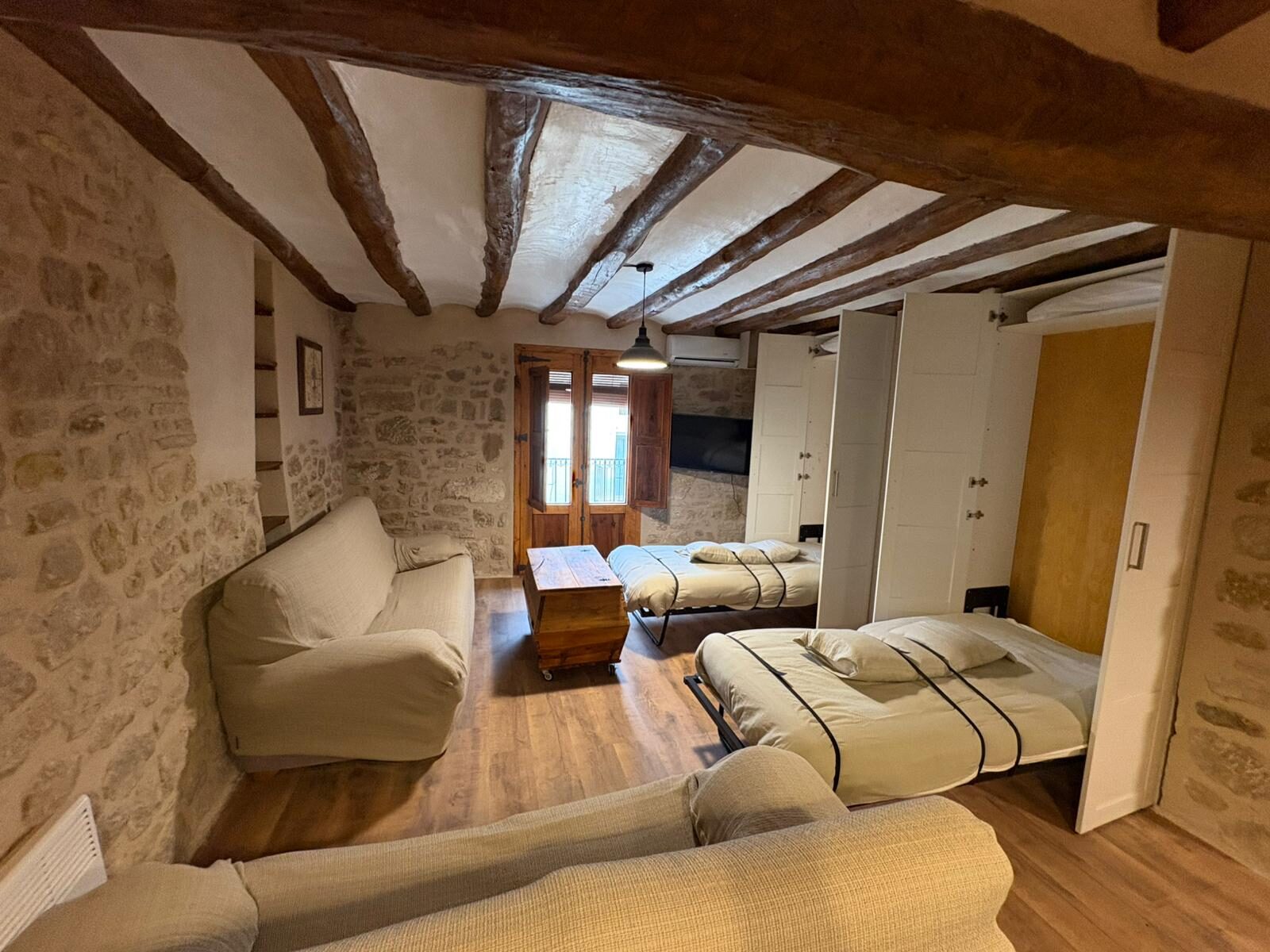 Salón con camas del apartamento Isabel, bajo vigas de madera